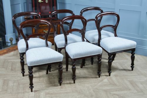 fig 1. A set of six Victorian mahogany balloon back dining chairs featuring turned front legs and light grey chevron-patterned upholstered seats.