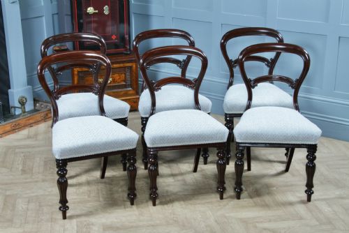 fig 2. A set of six Victorian mahogany balloon back dining chairs featuring turned front legs and light grey chevron-patterned upholstered seats.
