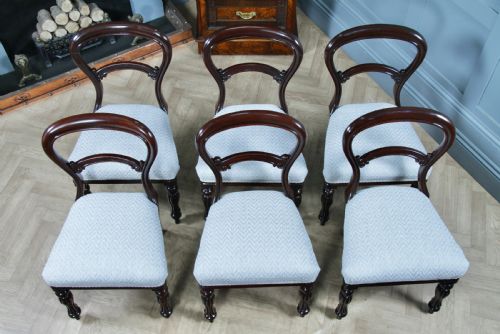 fig 3. A set of six Victorian mahogany balloon back dining chairs featuring turned front legs and light grey chevron-patterned upholstered seats.