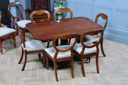 fig 1. A set of eight Victorian mahogany dining chairs featuring open rounded balloon backs, turned front legs, and neutral patterned upholstered seats.