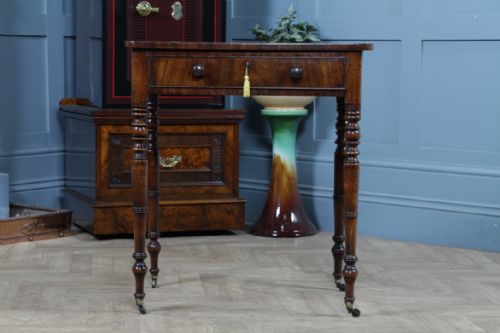 fig 2. A small Georgian flame mahogany side table featuring a single drawer with turned knobs, ring-turned legs, and brass castors.