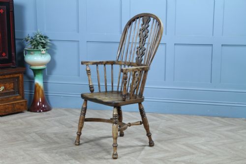 fig 2. A traditional high-back Windsor armchair crafted from ash and elm wood, featuring a pierced central splat, spindled backrest, turned legs, and a cow horn stretcher.