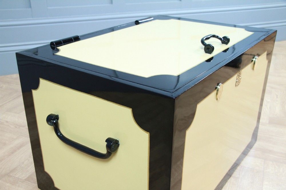 A restored Victorian George Price iron strong box with black painted edges, cream center panels, heavy iron handles, and a brass makers plaque. View VI