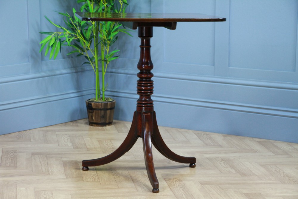 A Regency mahogany tilt-top wine table with a rounded square top, a turned column, and three splayed legs. View VI