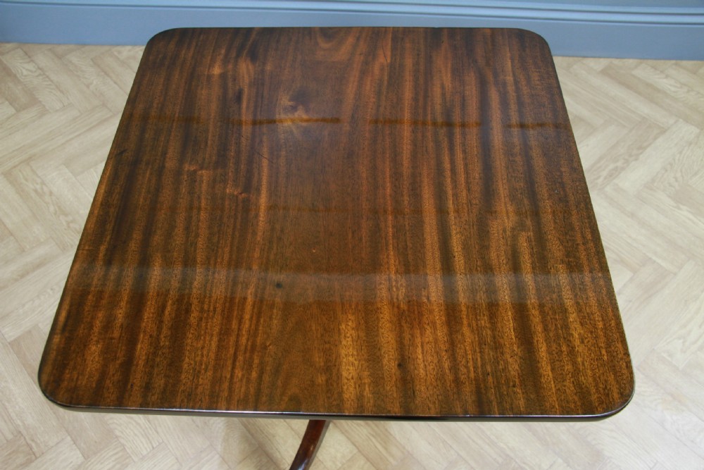 A Regency mahogany tilt-top wine table with a rounded square top, a turned column, and three splayed legs. View VII