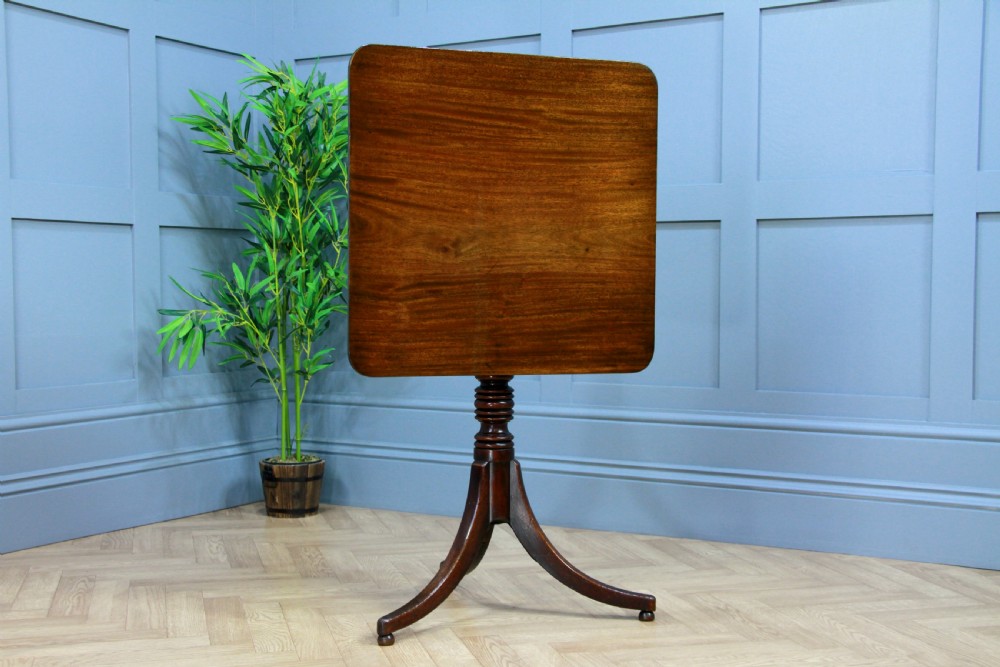 A Regency mahogany tilt-top wine table with a rounded square top, a turned column, and three splayed legs. View XIII