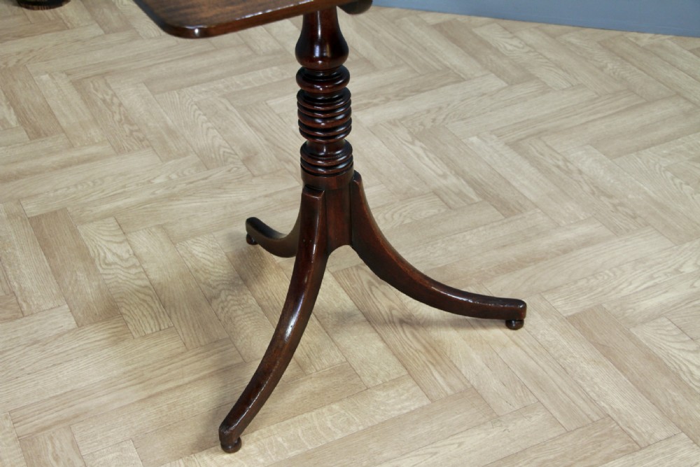 A Regency mahogany tilt-top wine table with a rounded square top, a turned column, and three splayed legs. View XV