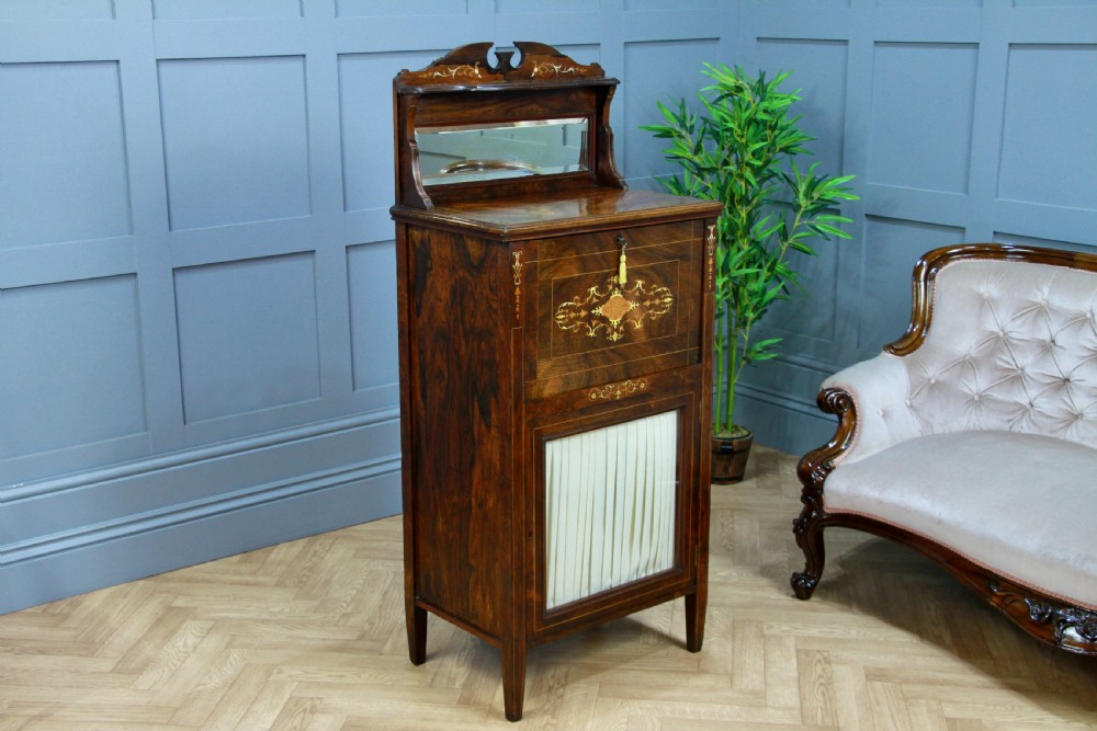 An Edwardian rosewood ladies bureau cabinet featuring marquetry inlay, a mirrored superstructure, a fall-front desk section, and a lower cupboard with a pleated fabric panel. View II