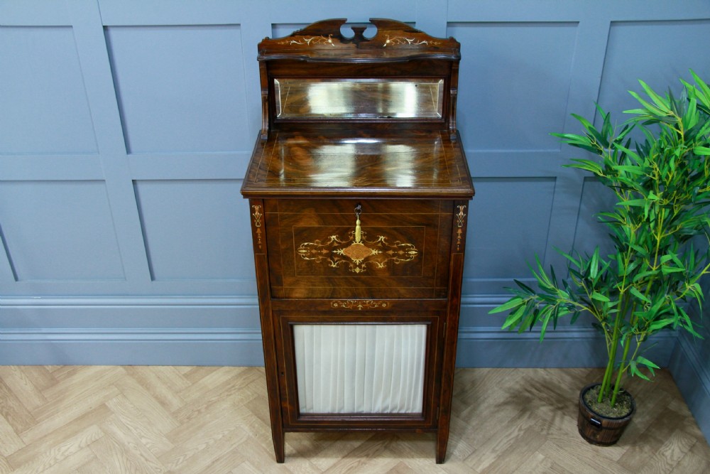 An Edwardian rosewood ladies bureau cabinet featuring marquetry inlay, a mirrored superstructure, a fall-front desk section, and a lower cupboard with a pleated fabric panel. View III