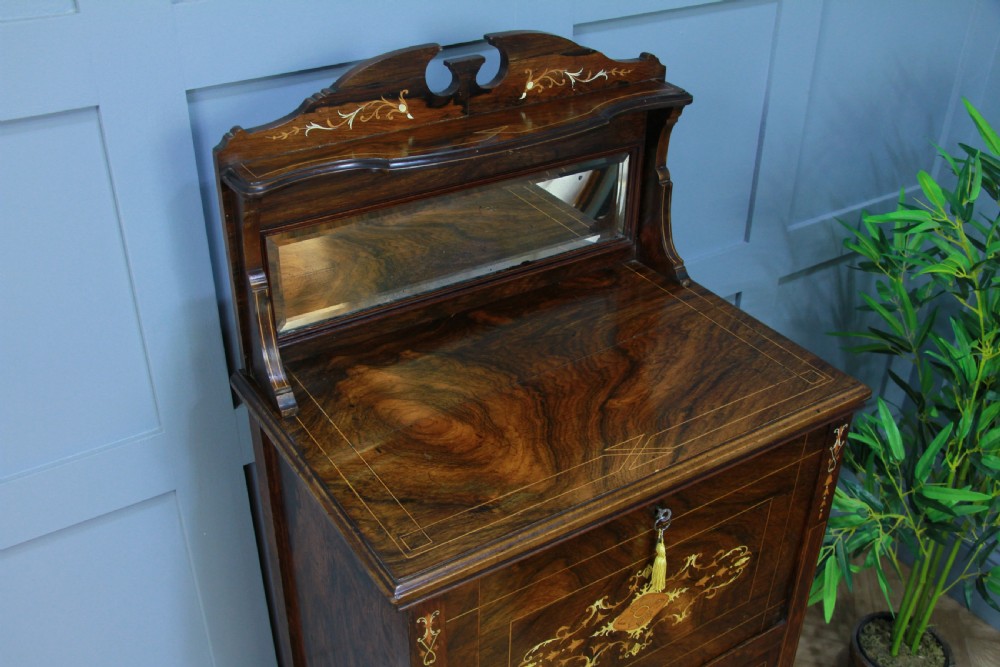An Edwardian rosewood ladies bureau cabinet featuring marquetry inlay, a mirrored superstructure, a fall-front desk section, and a lower cupboard with a pleated fabric panel. View V