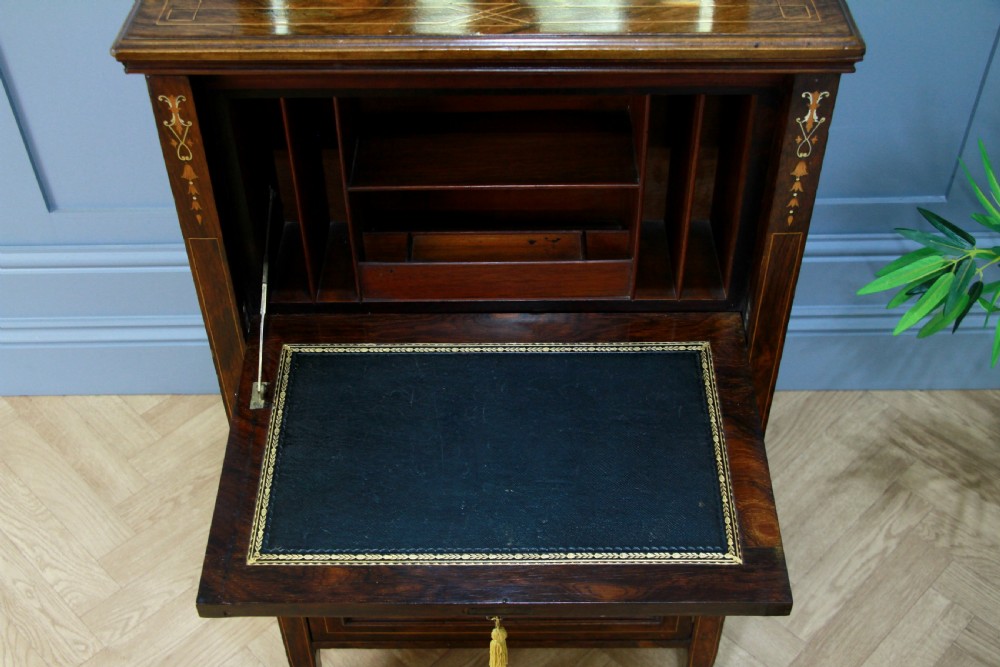 An Edwardian rosewood ladies bureau cabinet featuring marquetry inlay, a mirrored superstructure, a fall-front desk section, and a lower cupboard with a pleated fabric panel. View VIII