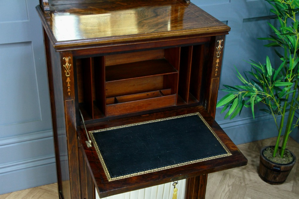 An Edwardian rosewood ladies bureau cabinet featuring marquetry inlay, a mirrored superstructure, a fall-front desk section, and a lower cupboard with a pleated fabric panel. View IX