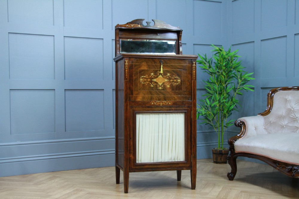An Edwardian rosewood ladies bureau cabinet featuring marquetry inlay, a mirrored superstructure, a fall-front desk section, and a lower cupboard with a pleated fabric panel. View XII