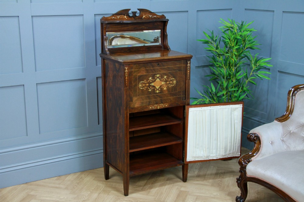 An Edwardian rosewood ladies bureau cabinet featuring marquetry inlay, a mirrored superstructure, a fall-front desk section, and a lower cupboard with a pleated fabric panel. View XIII