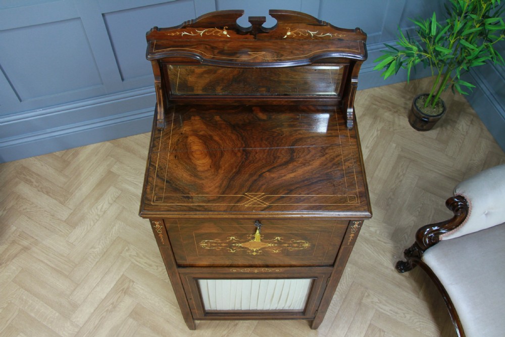 An Edwardian rosewood ladies bureau cabinet featuring marquetry inlay, a mirrored superstructure, a fall-front desk section, and a lower cupboard with a pleated fabric panel. View XIV