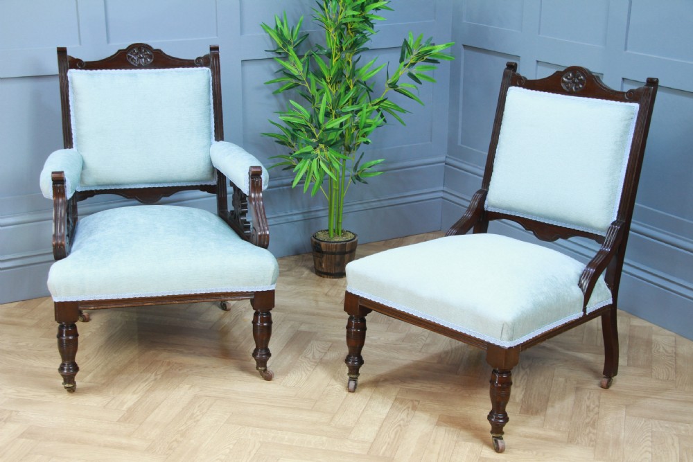 Pair of Edwardian mahogany armchairs upholstered in pale blue fabric featuring carved crestings and turned legs with brass castors. View III