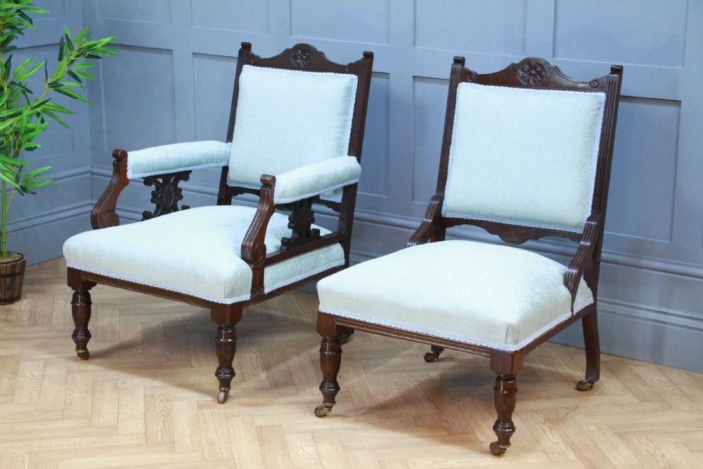 Pair of Edwardian mahogany armchairs upholstered in pale blue fabric featuring carved crestings and turned legs with brass castors. View IV