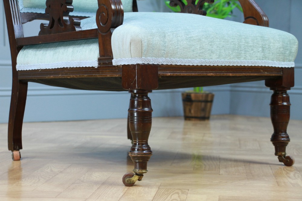 Pair of Edwardian mahogany armchairs upholstered in pale blue fabric featuring carved crestings and turned legs with brass castors. View VI