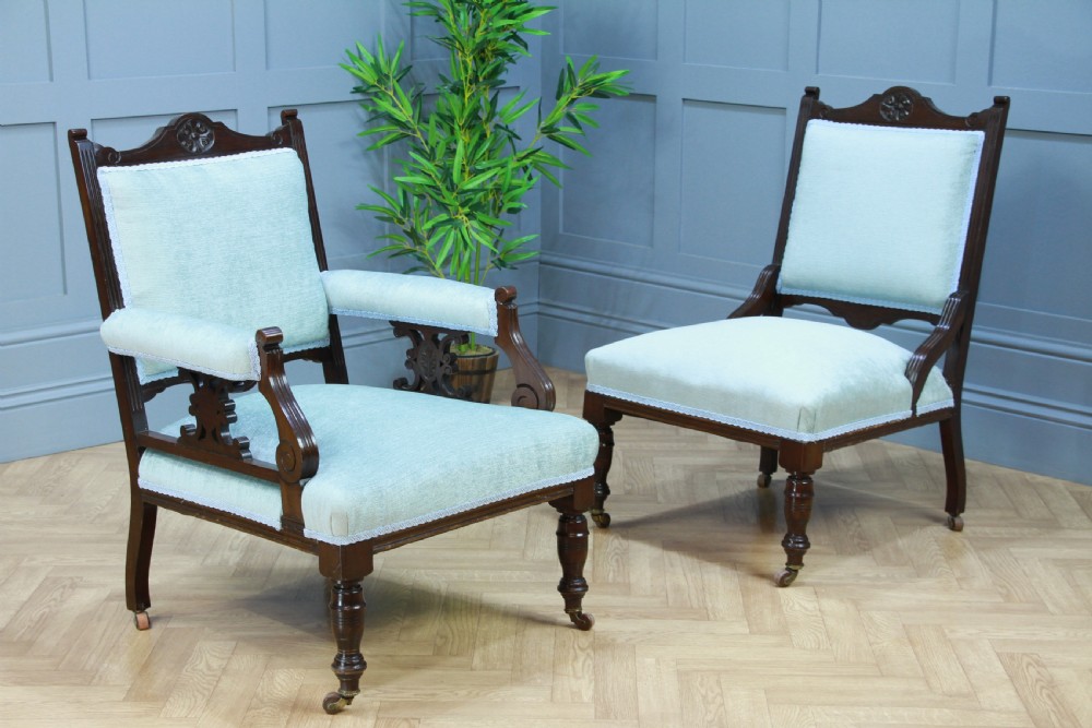Pair of Edwardian mahogany armchairs upholstered in pale blue fabric featuring carved crestings and turned legs with brass castors. View VII