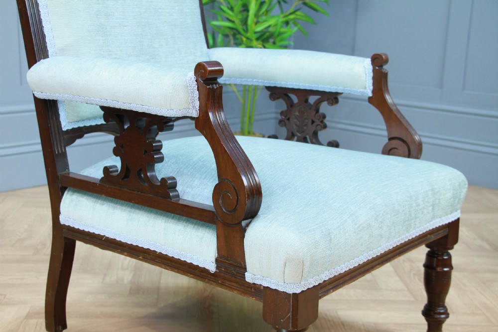 Pair of Edwardian mahogany armchairs upholstered in pale blue fabric featuring carved crestings and turned legs with brass castors. View IX