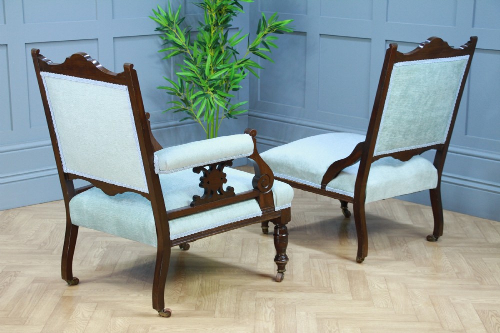 Pair of Edwardian mahogany armchairs upholstered in pale blue fabric featuring carved crestings and turned legs with brass castors. View XI