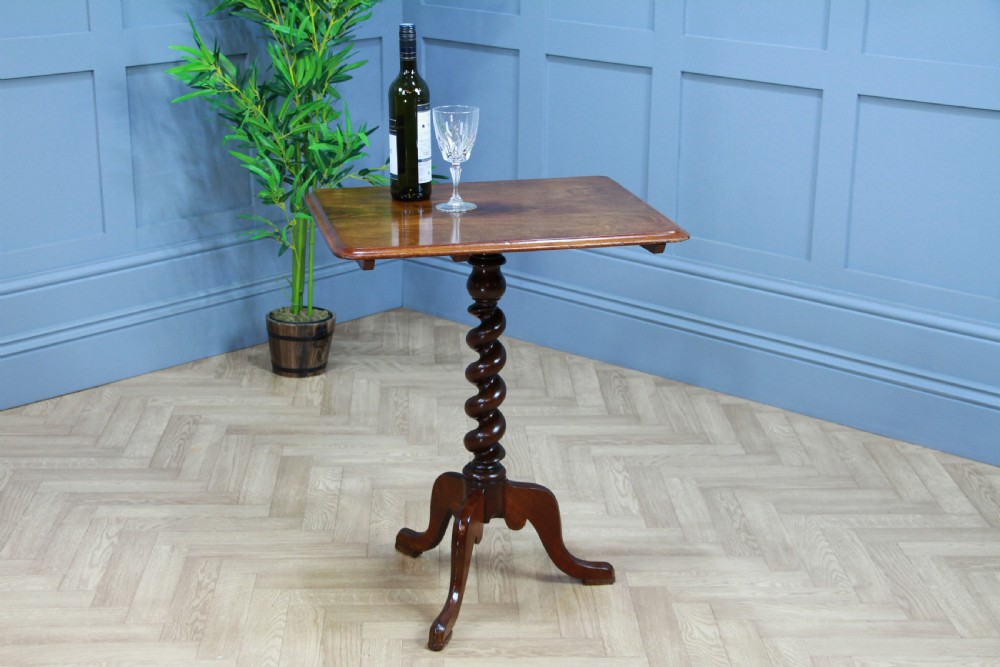 A Victorian flame mahogany tilt-top wine table with a rectangular top, spiral barley twist column, and tripod base. View XV