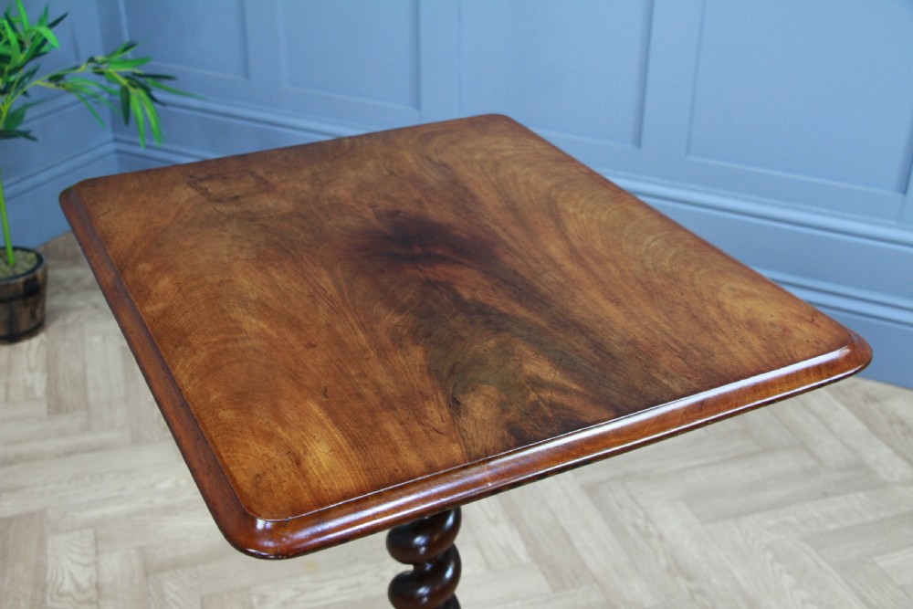 A Victorian flame mahogany tilt-top wine table with a rectangular top, spiral barley twist column, and tripod base. View VII