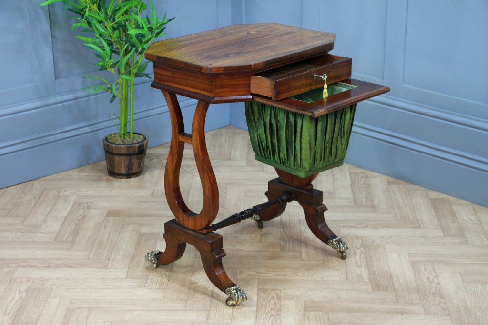 An antique Regency kingwood work table featuring lyre-shaped side supports, a suspended green pleated fabric box, and brass paw feet on castors. View V