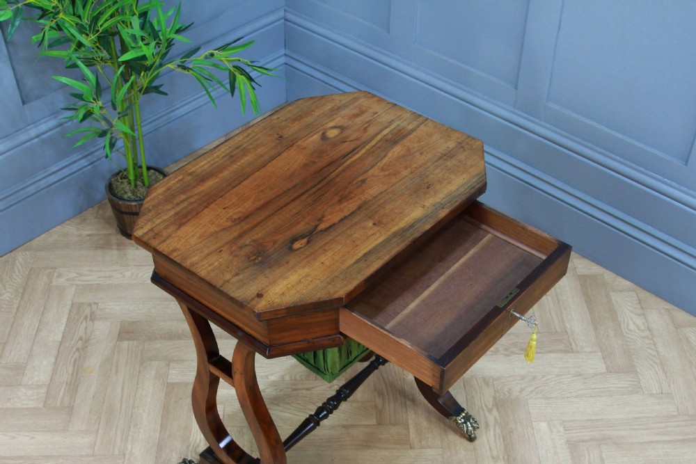 An antique Regency kingwood work table featuring lyre-shaped side supports, a suspended green pleated fabric box, and brass paw feet on castors. View VI
