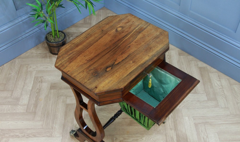 An antique Regency kingwood work table featuring lyre-shaped side supports, a suspended green pleated fabric box, and brass paw feet on castors. View VII