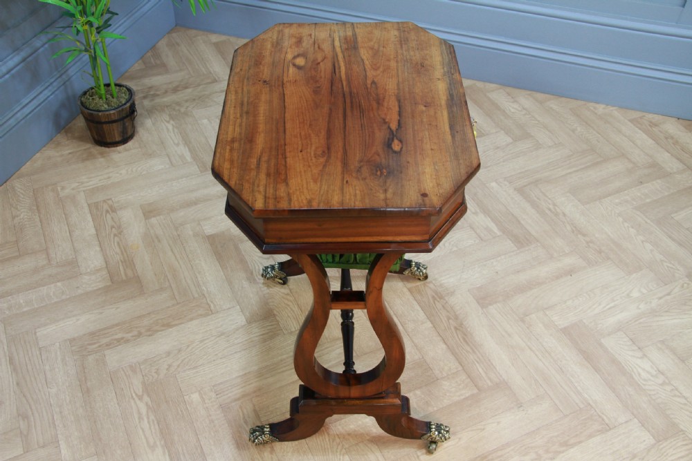 An antique Regency kingwood work table featuring lyre-shaped side supports, a suspended green pleated fabric box, and brass paw feet on castors. View VIII