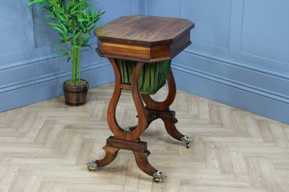 An antique Regency kingwood work table featuring lyre-shaped side supports, a suspended green pleated fabric box, and brass paw feet on castors. View XII