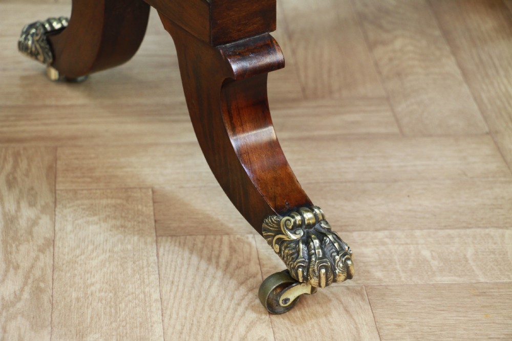An antique Regency kingwood work table featuring lyre-shaped side supports, a suspended green pleated fabric box, and brass paw feet on castors. View XIV