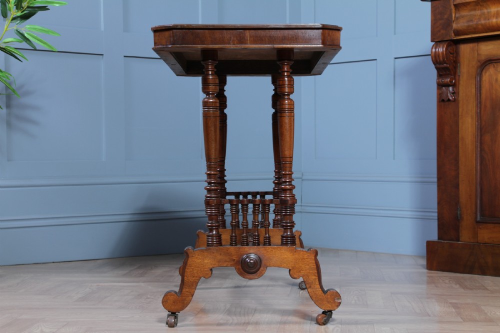 A late Victorian turned walnut occasional table featuring a rectangular top, twin turned end supports, a low stretcher, and feet set on castors. View VI