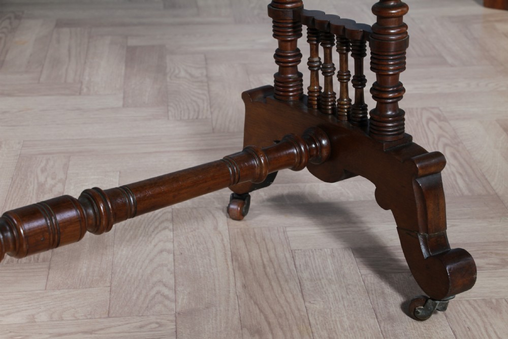 A late Victorian turned walnut occasional table featuring a rectangular top, twin turned end supports, a low stretcher, and feet set on castors. View XI