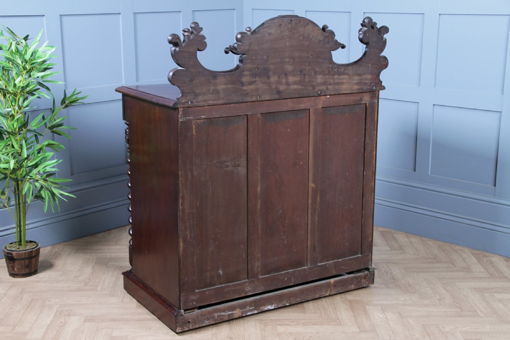 A 19th-century dark mahogany chiffonier featuring two top drawers, two carved panel cupboard doors, barley twist side columns, and a carved scroll splashback. View XX