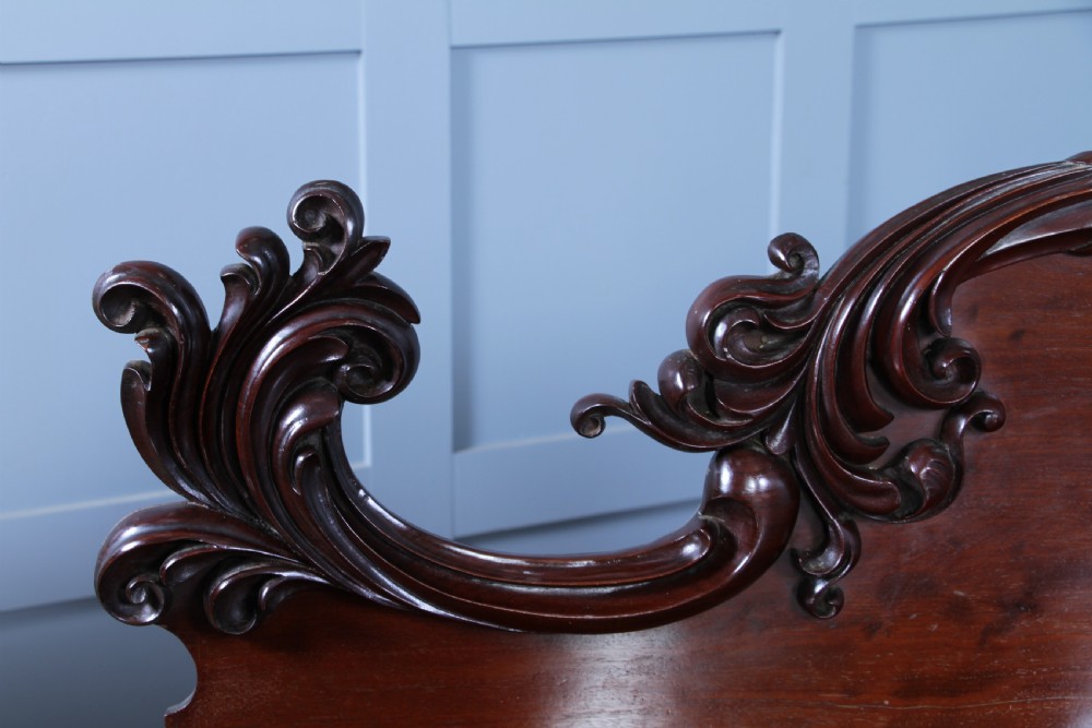 A 19th-century dark mahogany chiffonier featuring two top drawers, two carved panel cupboard doors, barley twist side columns, and a carved scroll splashback. View XXIV