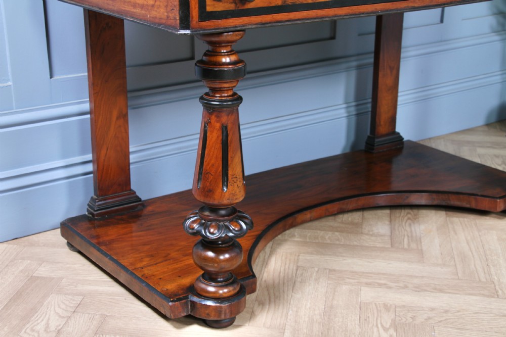 An antique Victorian burr walnut duchess dressing table featuring an integrated swing mirror, jewellery drawers, a curved piano top lid, turned front legs, and a plinth base. View XII