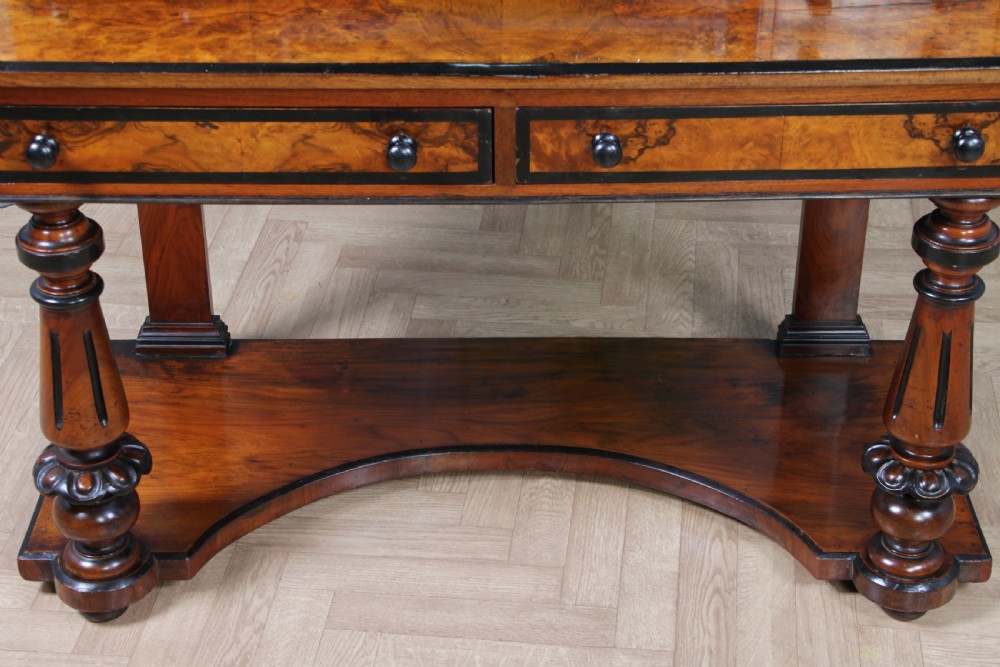 An antique Victorian burr walnut duchess dressing table featuring an integrated swing mirror, jewellery drawers, a curved piano top lid, turned front legs, and a plinth base. View XXIII