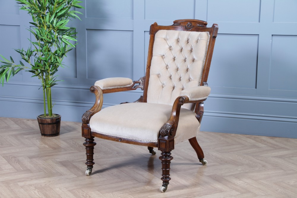 A Victorian carved walnut two-piece salon suite comprising a button-tufted cream velvet sofa and a matching armchair on turned legs with castors. View III