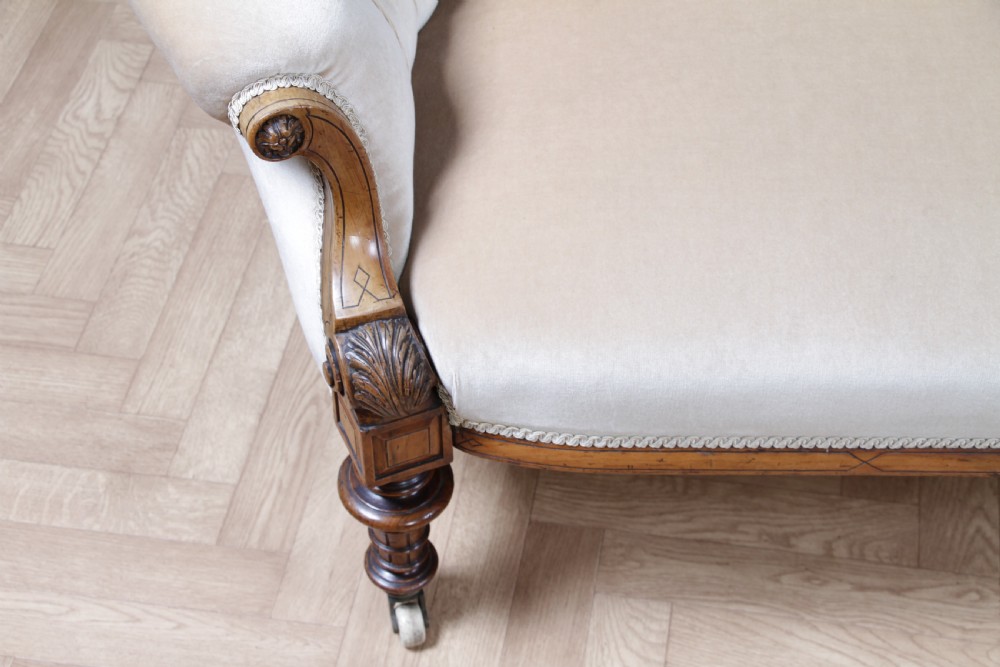 A Victorian carved walnut two-piece salon suite comprising a button-tufted cream velvet sofa and a matching armchair on turned legs with castors. View XIII