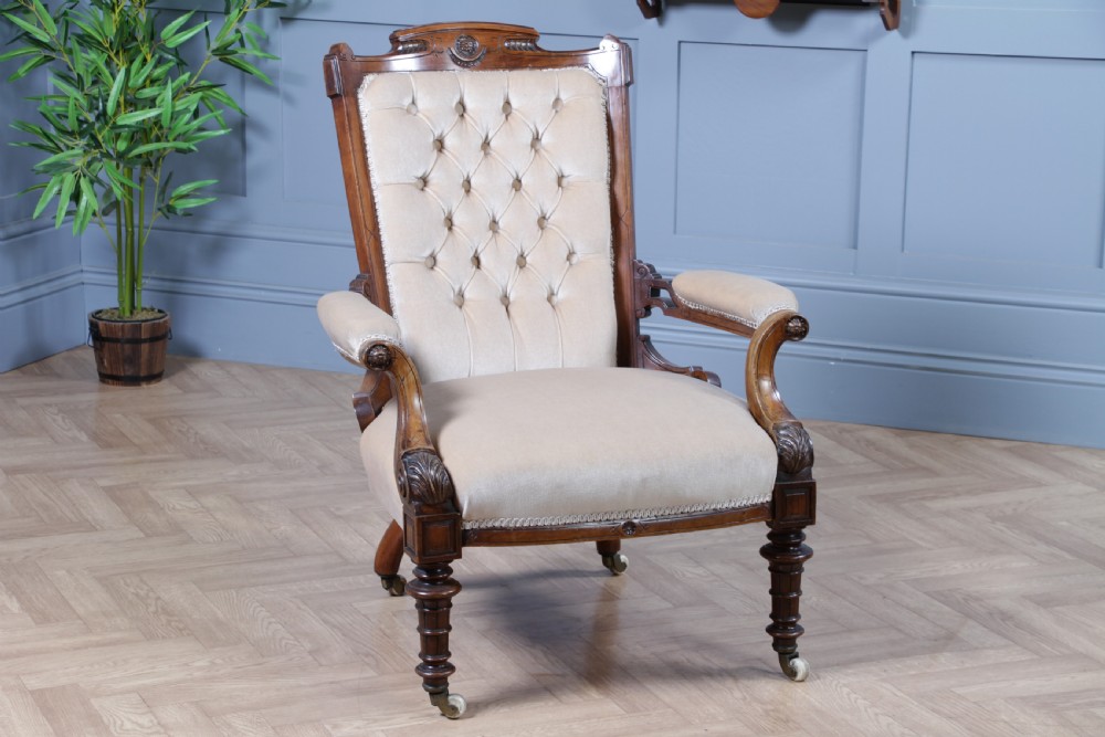 A Victorian carved walnut two-piece salon suite comprising a button-tufted cream velvet sofa and a matching armchair on turned legs with castors. View XXIII
