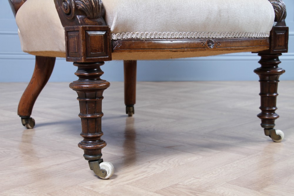 A Victorian carved walnut two-piece salon suite comprising a button-tufted cream velvet sofa and a matching armchair on turned legs with castors. View XXXI