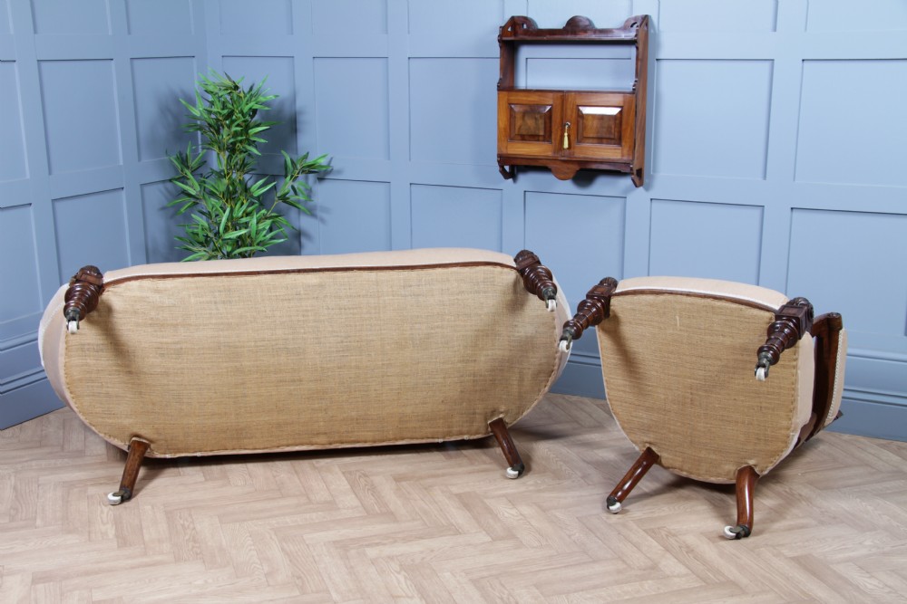 A Victorian carved walnut two-piece salon suite comprising a button-tufted cream velvet sofa and a matching armchair on turned legs with castors. View XXXII