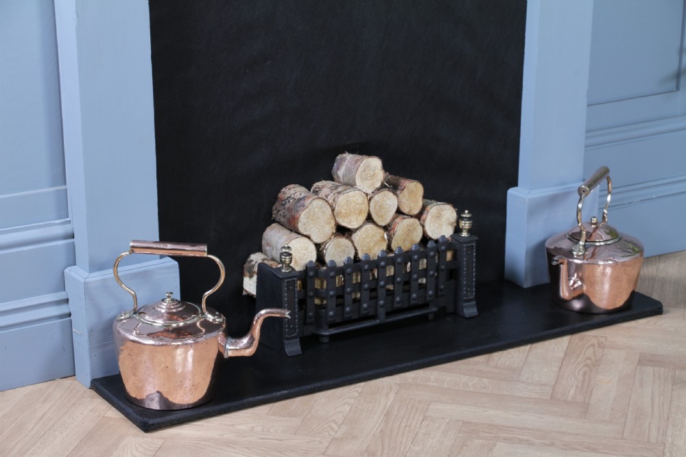 A polished George III copper kettle with a raised brass fixed handle and a curved gooseneck spout. View III