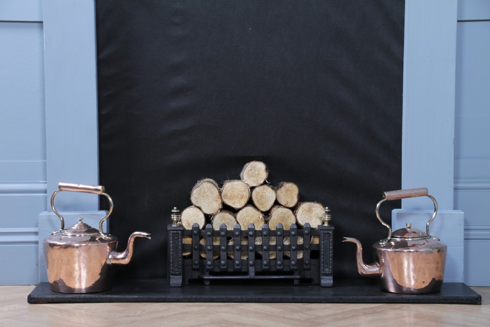 An antique George III polished copper kettle featuring a brass finial lid, overhead handle, and curved spout. View XI