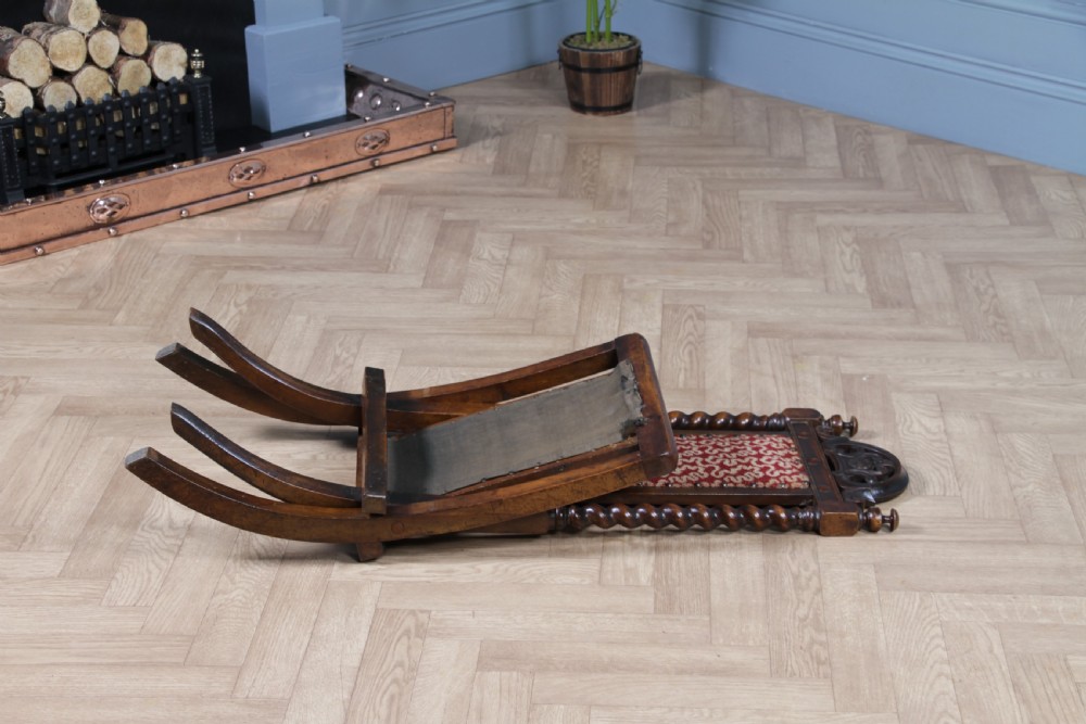 Late Victorian dark wood folding chair featuring barley twist uprights, a carved crest rail, red patterned upholstery, and brass stud trim. View III