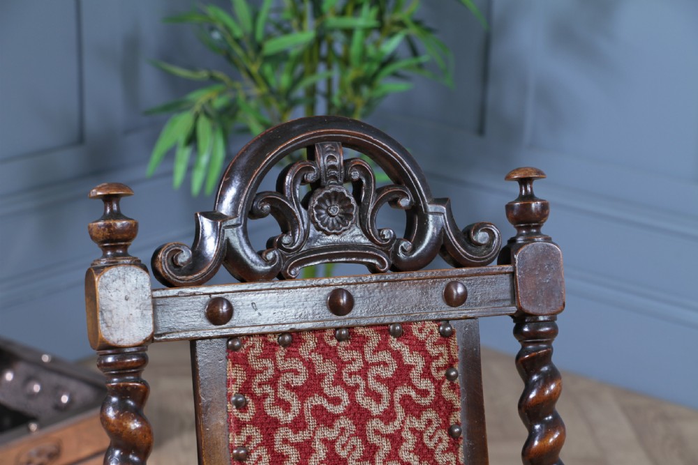 Late Victorian dark wood folding chair featuring barley twist uprights, a carved crest rail, red patterned upholstery, and brass stud trim. View VIII