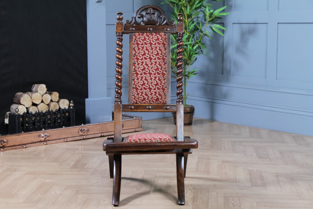Late Victorian dark wood folding chair featuring barley twist uprights, a carved crest rail, red patterned upholstery, and brass stud trim. View XVI