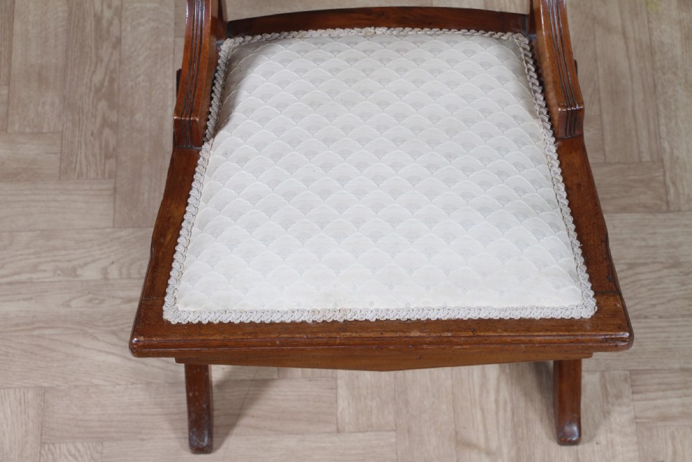 An Edwardian walnut platform rocking chair featuring cream button-backed upholstery and turned wooden spindles on a stationary crossed base. View XI